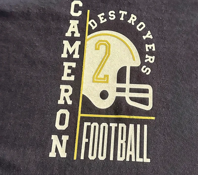 Navy shirt with a shimmering cream and gold design reading Cameron Destroyers Football with a football helmet and the number 2